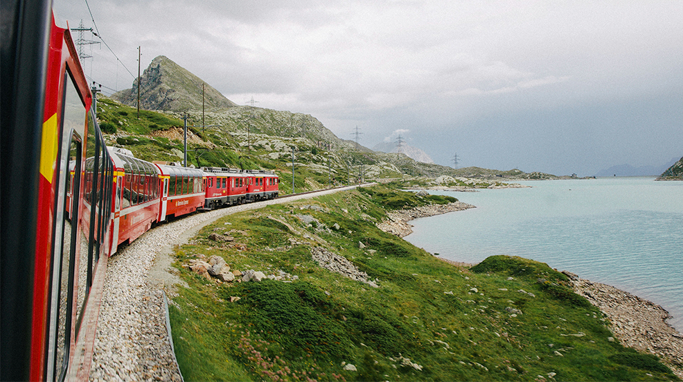 An interrailing train passing through a beautiful coastal landscape